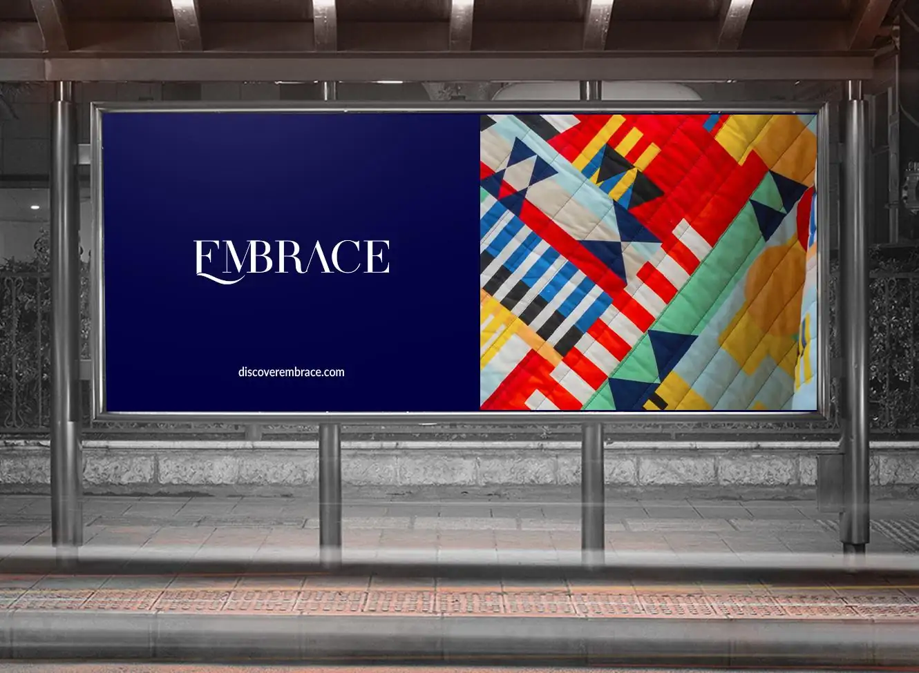 An Embrace billboard: the wordmark in white on deep navy beside a panel of bold patchwork textile