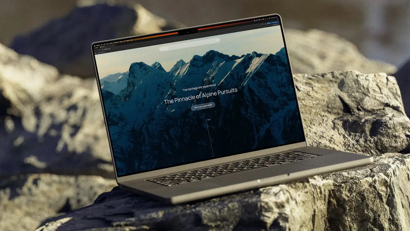 A laptop resting on rock showing the Alto homepage \u2014 The Pinnacle of Alpine Pursuits over a mountain range at dusk