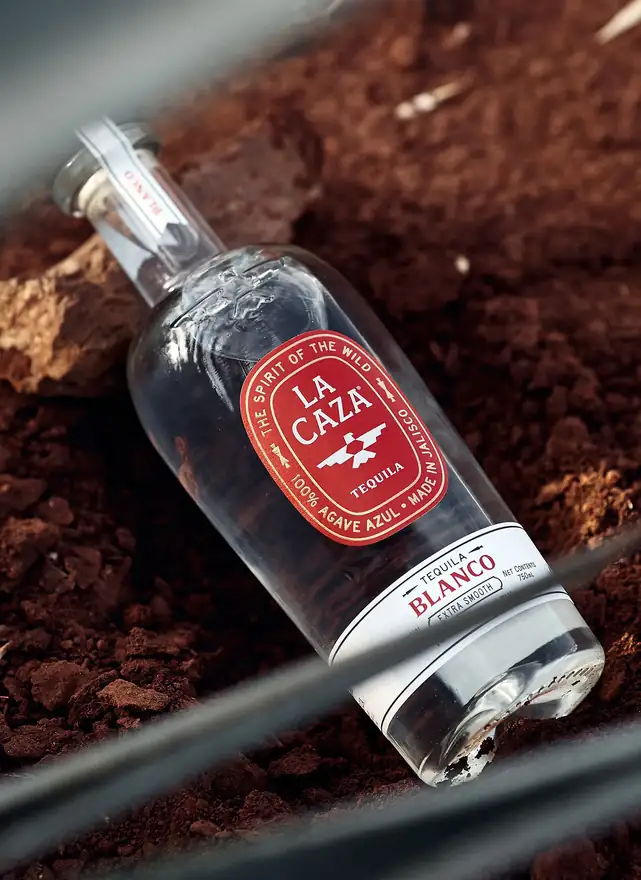 La Caza Blanco with its red oval label, lying in red earth