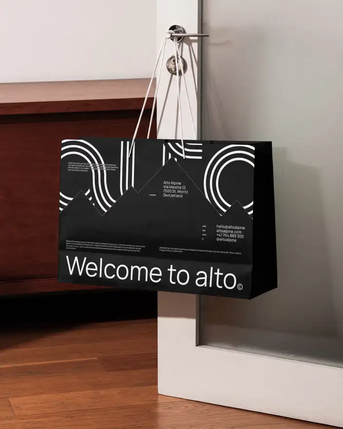 A black Alto shopping bag reading Welcome to alto, printed with line-drawn peaks and address details