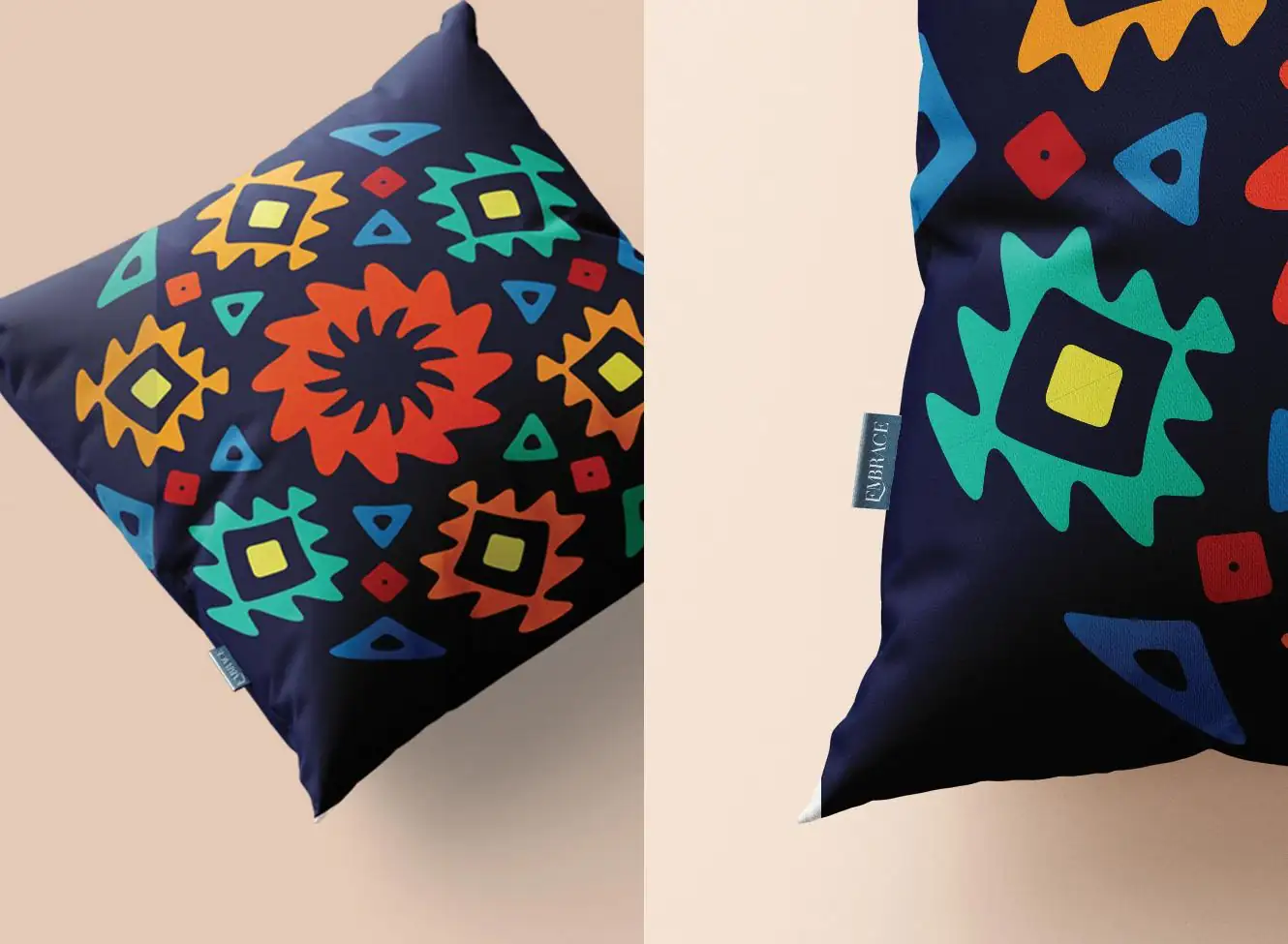 Two navy Embrace cushions covered in bold orange, teal, yellow and red geometric motifs, one shown close up with a woven brand label