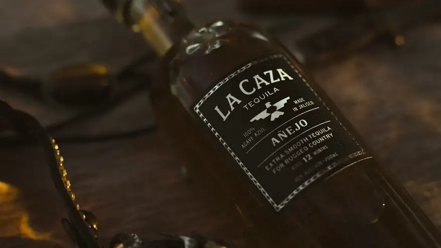 Close-up of the black and gold La Caza A\u00f1ejo label in low light